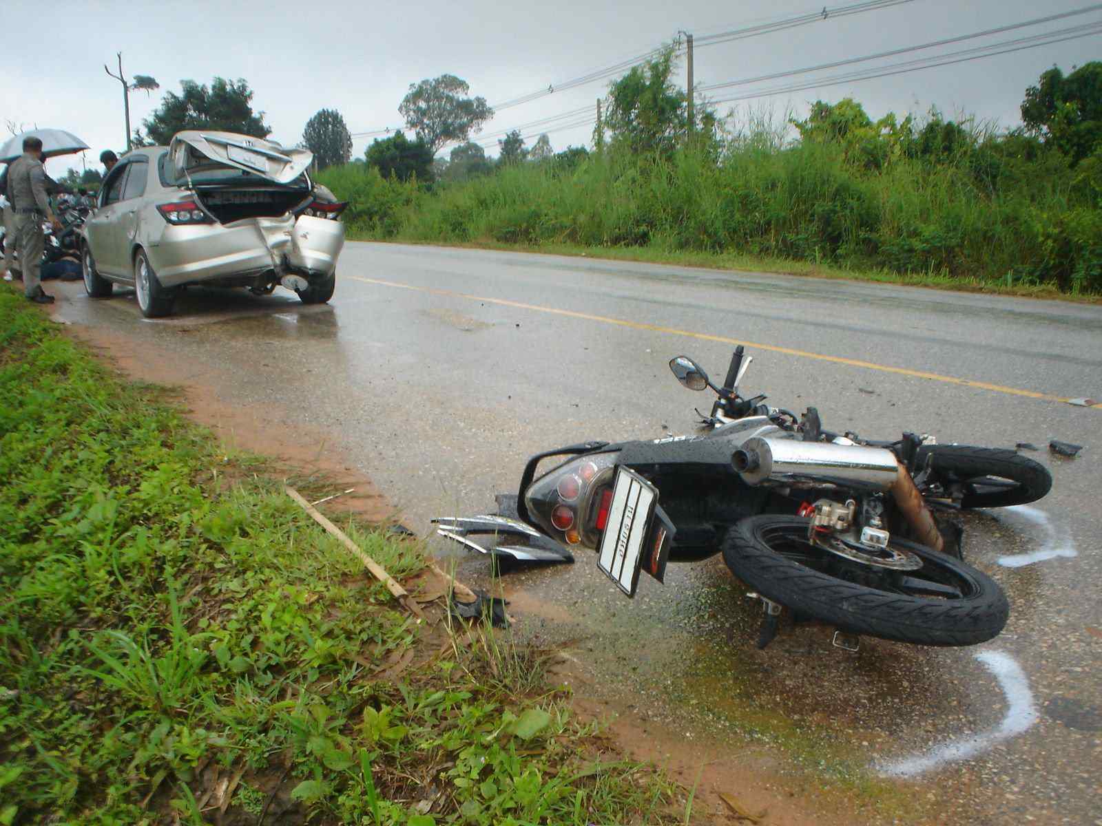 Motorcycle accident scene on roadside and damaged car illustrating personal injury claims and cruise ship