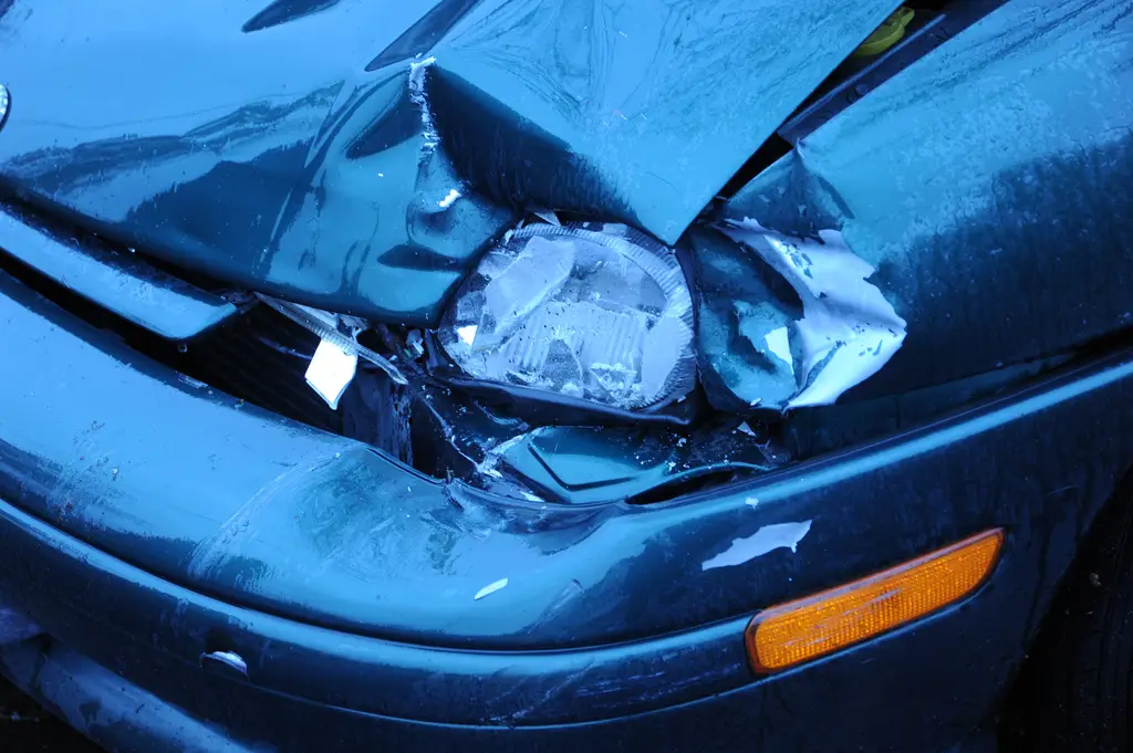 Damaged blue car after a Florida auto accident, car accident claim factors.