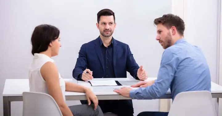 Mediation process with attorney and clients discussing legal case resolution.