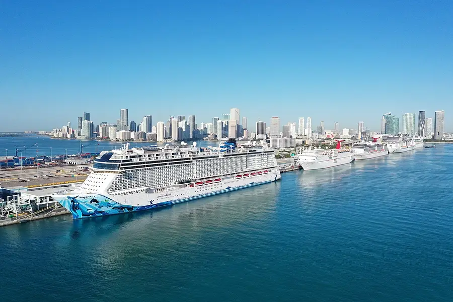 Cruise ships docked at Port Miami with city skyline in the background, highlighting the resumption of cruise operations post-COVID-19.