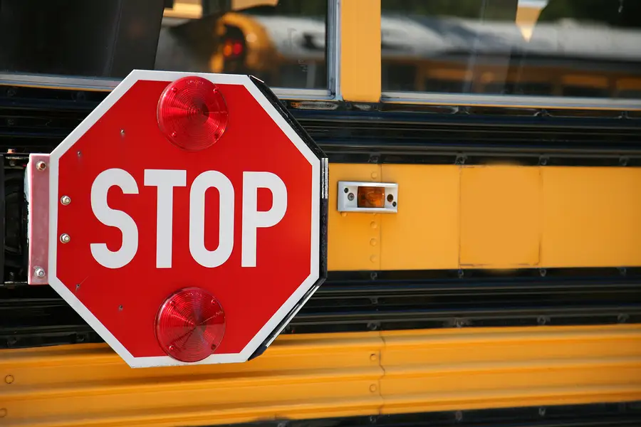 Stop sign on a school bus emphasizing back-to-school safety for children walking and biking to school.