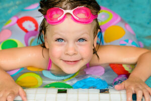 funny little girl swimming in a pool