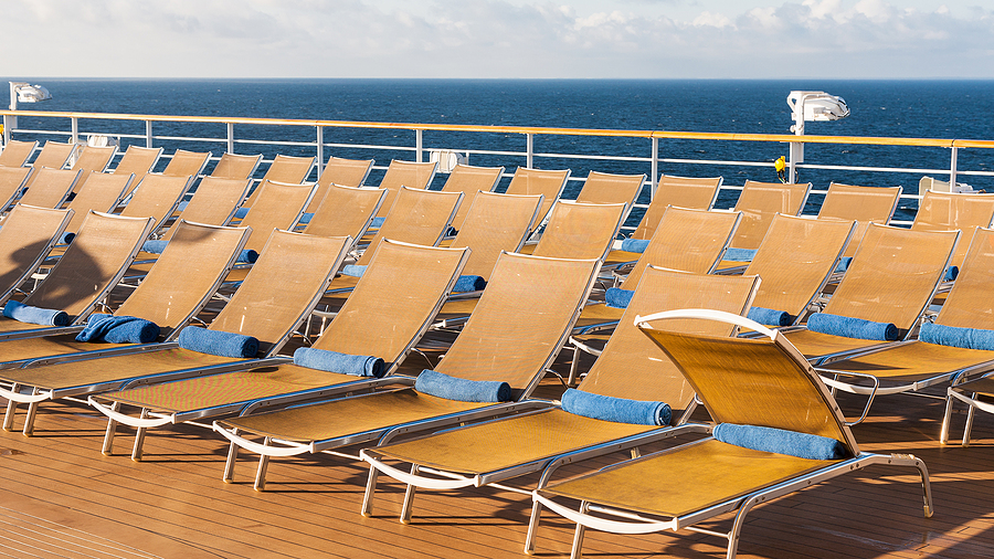 many empty chairs in relaxation area on stern of cruise liner