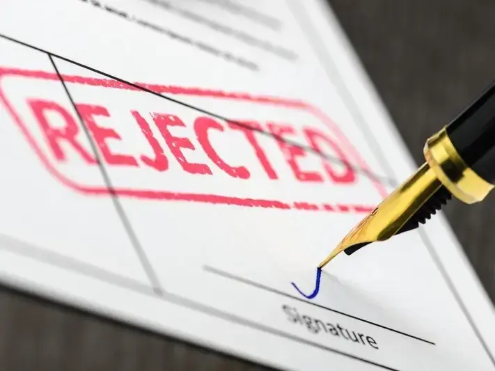 Rejected document with a bold red stamp and a fountain pen signing below the signature line.