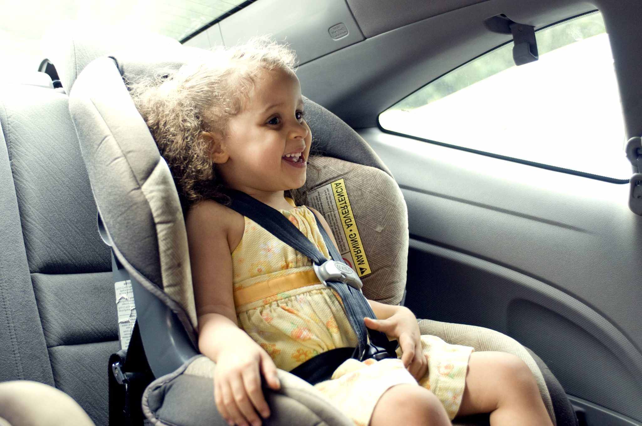 young cute female child in back seat car set min