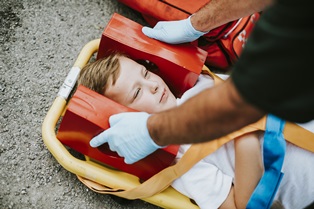 young injured boy lying on an ambulance stretcher
