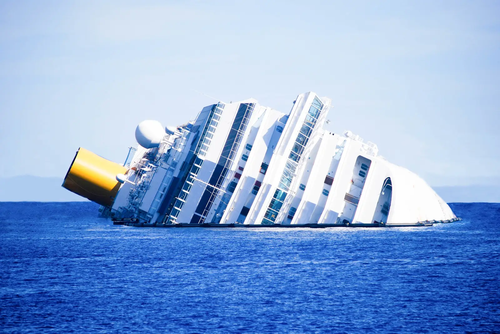 Capsized cruise ship partially submerged in ocean, illustrating maritime accidents and personal injury risks associated with cruise travel.