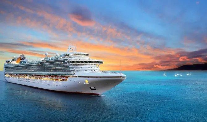 Cruise ship sailing in calm waters at sunset, representing maritime travel and tourism in Saudi Arabia.