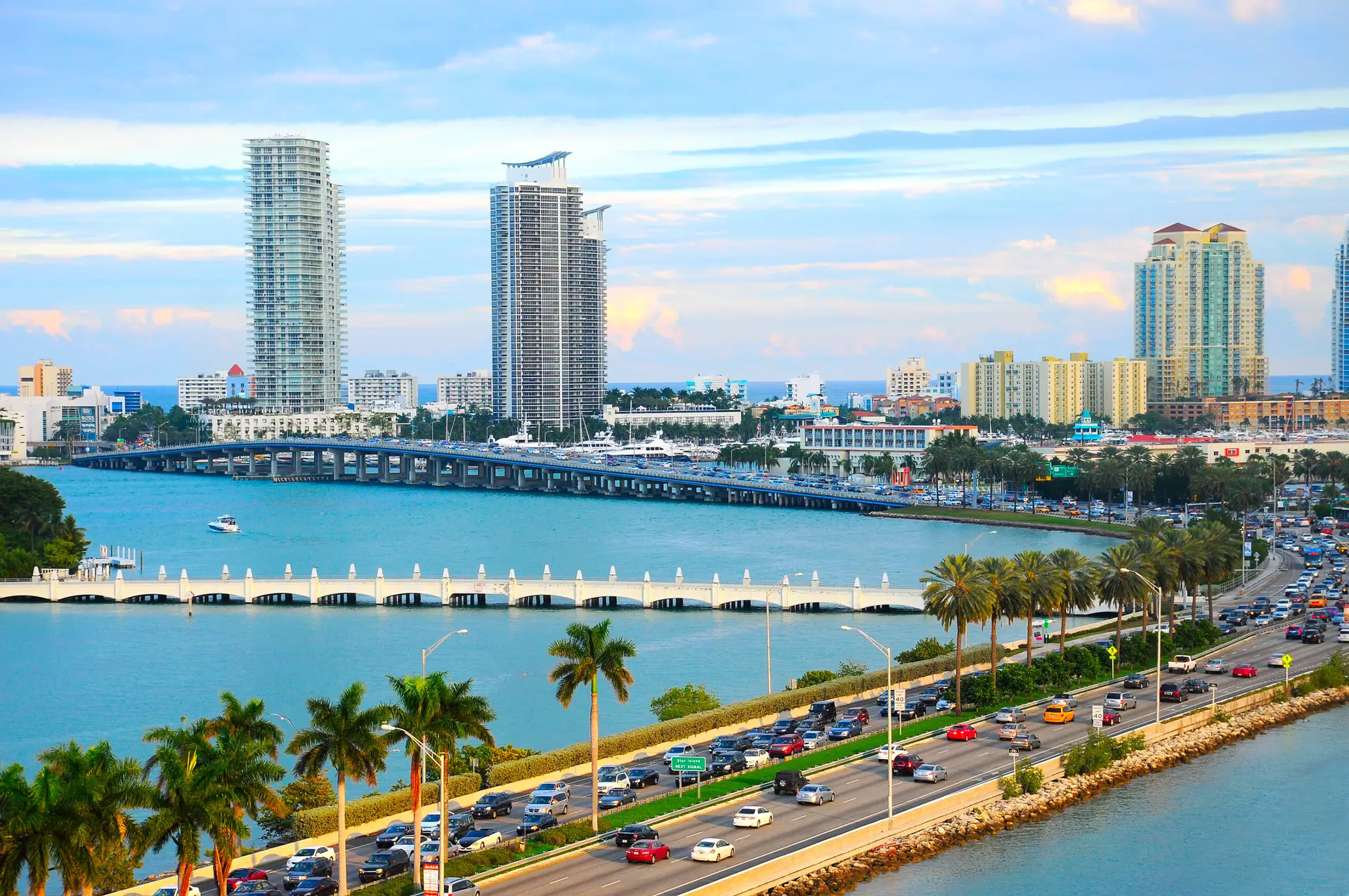 Miami city skyline with high-rise buildings, a busy road with cars, and a bridge over blue water, illustrating urban life and traffic conditions relevant to safety discussions in personal injury law.