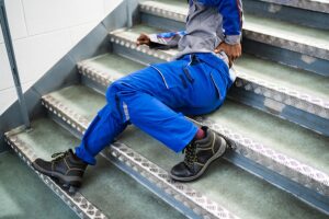 worker man lying on staircase after slip and fall accident