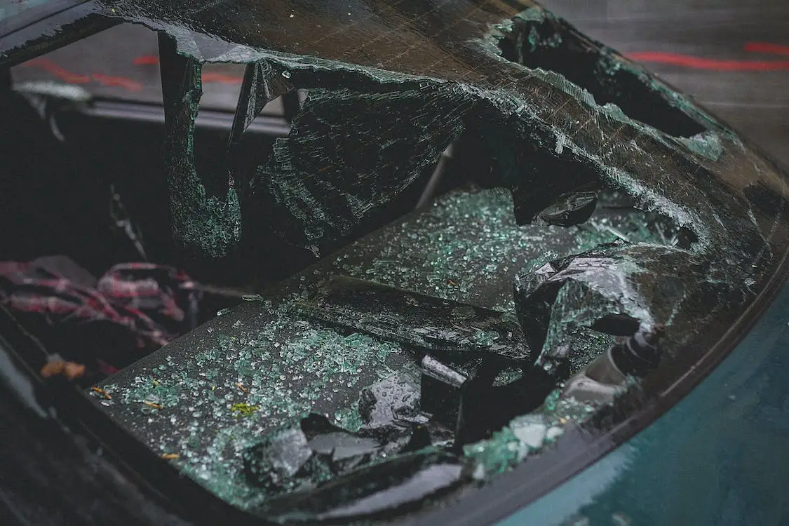 Shattered car window with broken glass pieces, illustrating the aftermath of a car accident related to negligence and safety concerns.
