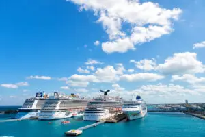 Nassau, Bahamas - February 18, 2016: Large luxury cruise ships of Carnival Norwegian and Royal Caribbean cruise lines docked in port of Nassau Bahamas on sea water and cloudy sky background