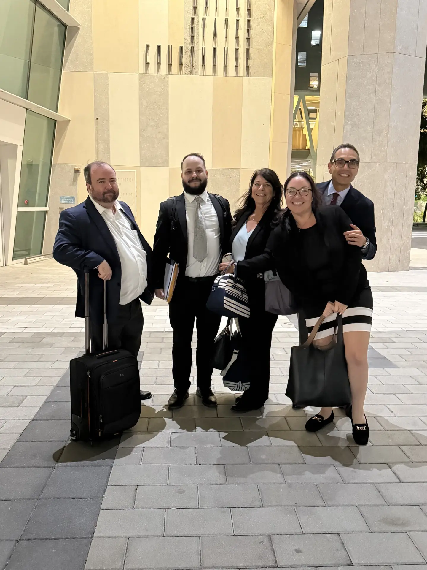 Group of five Aronfeld Trial Lawyers attorneys posing outside a courthouse, dressed in professional attire, with legal documents and bags, symbolizing their commitment to maritime law and personal injury cases.